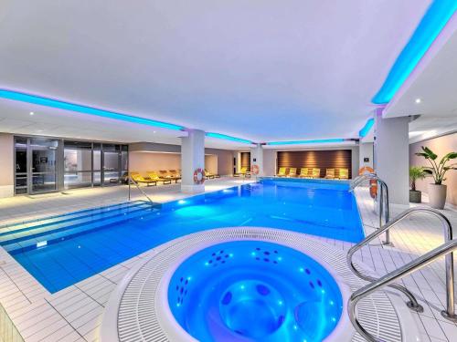 una gran piscina en un hotel con una bañera grande en Novotel Kraków Centrum, en Cracovia