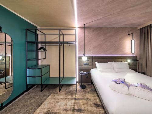 um quarto com uma grande cama branca e uma parede verde em Novotel Kraków Centrum na Cracóvia