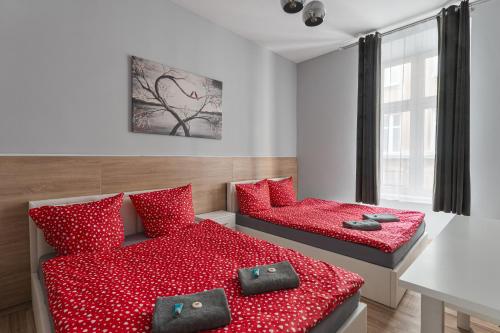 a bedroom with two beds with red pillows at 70s Guest room in Kraków