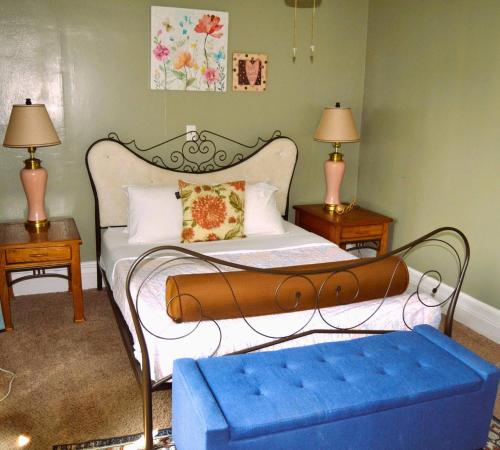 een slaapkamer met een bed met een blauwe poef bij 7-Bedroom Retreat Sleeps 13 in East Grand Forks