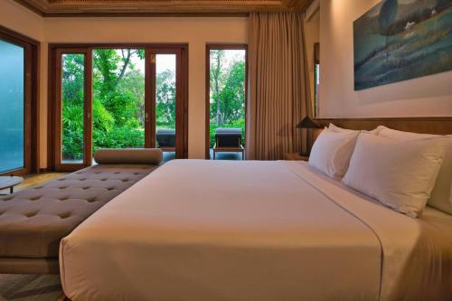a large white bed in a room with windows at Legacy Mekong, Can Tho, Autograph Collection in Can Tho