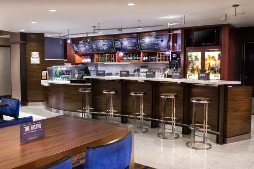 a bar in a restaurant with a wooden counter and stools at Courtyard by Marriott Columbia in Columbia