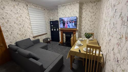 a living room with a couch and a table and a television at Pat Signature Stays in Kingsthorpe