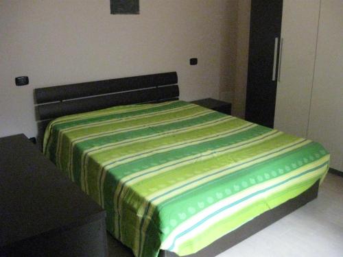 1 dormitorio con 1 cama con manta verde y amarilla en Eutimo, en Locri