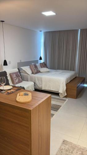 a hotel room with two beds and a table with a desk at Apartamento Milla 1 in Pomerode