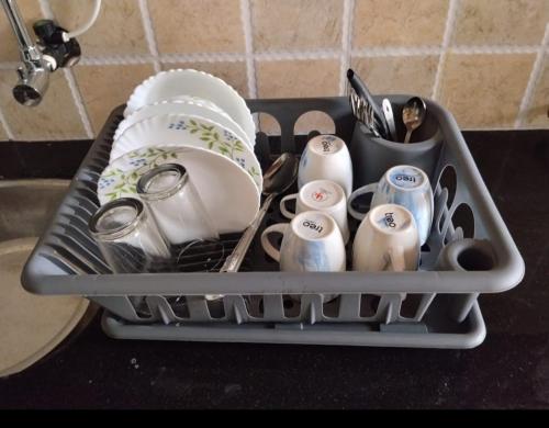 ein Geschirrständer voller Geschirr und Besteck in der Unterkunft palolem beach residency in Canacona