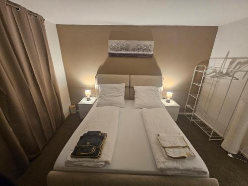 a large bed in a small room with two lamps at Zentrale & gemütliche Wohnung in Wolfsburg in Wolfsburg