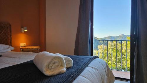 a bedroom with a bed and a window with a view at Hotel Rural Mirador de Jubrique in Jubrique