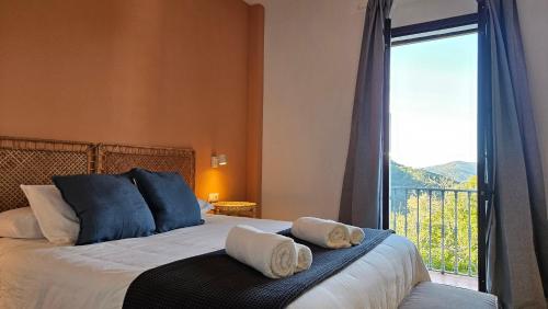 a bedroom with a bed and a large window at Hotel Rural Mirador de Jubrique in Jubrique