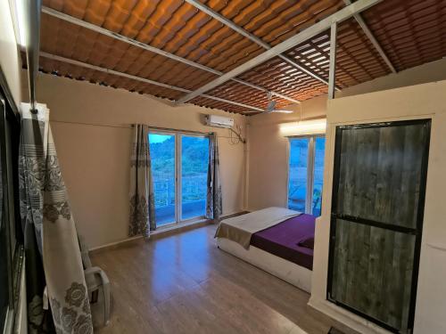 a bedroom with a bed and a large window at Sea view holiday resort in Borlai