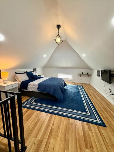 a bedroom with a bed and a blue rug at NYC-Style Loft with Secret Entrance - Just 6 Miles from Times Square in North Bergen