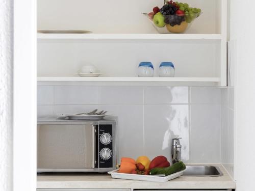 a kitchen with a microwave and a plate of fruit at Résidence Studio Genève Centre in Geneva