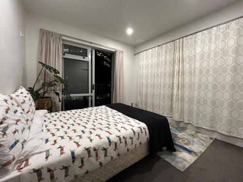 Un dormitorio con una cama y una ventana en Adjacent to the Sky Tower, with a super large space, en Auckland
