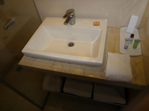 a white sink sitting on a counter in a bathroom at The Legend Inn @Nagpur in Nagpur