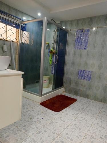 a bathroom with a shower with a glass door at TheGeneral Place in Ikorodu