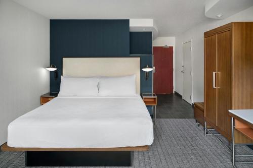 a bedroom with a large bed and a desk at Courtyard by Marriott Kansas City Shawnee in Shawnee