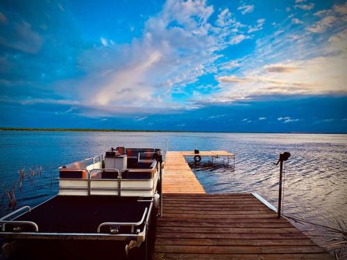 a boat tied to a dock on a body of water at Designer Lake Cabin- HotTub, Sauna & Massage Chair in Ottertail