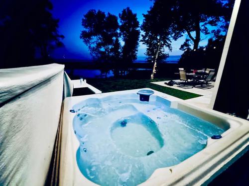 a jacuzzi tub with a view of the ocean at Designer Lake Cabin- HotTub, Sauna & Massage Chair in Ottertail