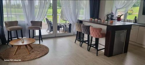 a kitchen with a bar with stools and a table at Lion Sauna in Vydmantai