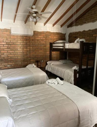 a room with three bunk beds and a ceiling at Hotel Boutique Colonial Cartago in Cartago