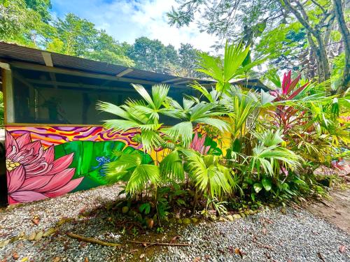 a colorful mural on a building with plants at Ita Ita Casitas Playa Punta Uva in Punta Uva