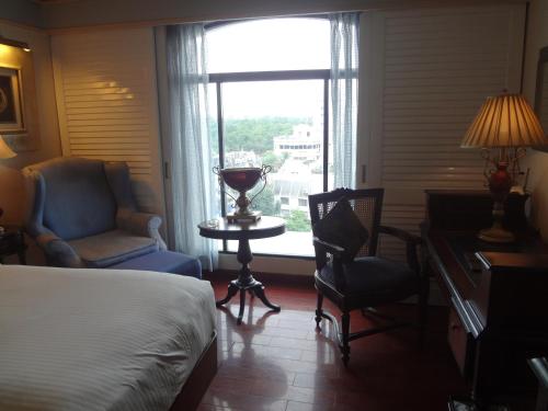 a hotel room with a bed and a desk and a window at Tuli Imperial in Nagpur
