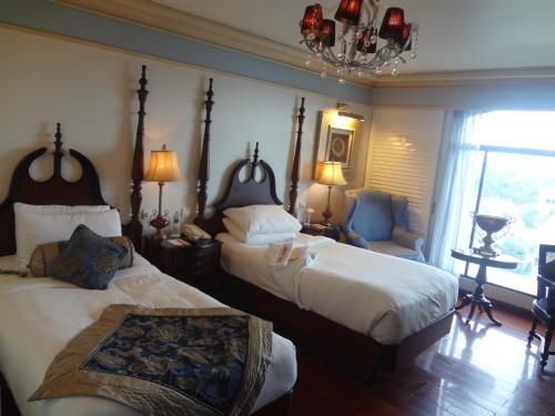 a hotel room with two beds and a chandelier at Tuli Imperial in Nagpur