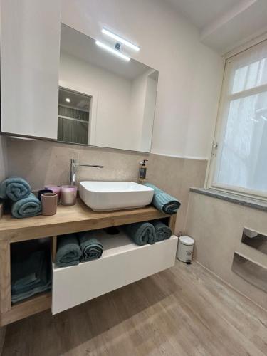 a bathroom with a sink and a mirror and towels at Appartamenti reali - I giardini reali in Venaria Reale