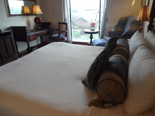 a bedroom with a large white bed with pillows at Tuli Imperial in Nagpur