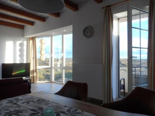 un soggiorno con un tavolo e un orologio a parete di Ankerplatz im Strandschlösschen a Baltrum