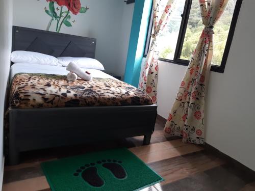 a bedroom with a bed and a green rug at Eco Hotel Parador de Rapi in Santa Rosa de Cabal