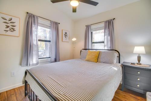 a bedroom with a bed and two windows at Deck and Boat Dock Lakefront Cabin in Eucha! in Eucha