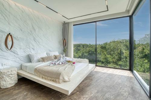 Snow White Villas 3BR Haven Near Pandawa Beach في أونغاسان: غرفة نوم بسرير أبيض ونافذة كبيرة
