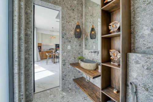 Snow White Villas 3BR Haven Near Pandawa Beach في أونغاسان: حمام مزود بحوض ومِرآة