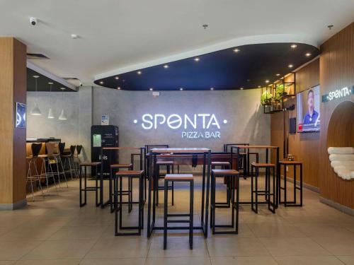 a restaurant with stools and a sign that reads sparta pizza bar at Ibis Salvador Rio Vermelho in Salvador