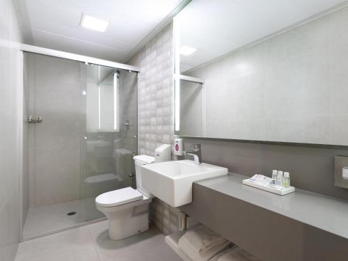 圣保罗圣保罗保利斯塔美居酒店的浴室里有洗手池、马桶和淋浴。