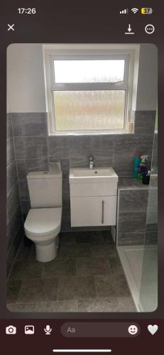 ein Badezimmer mit weißer Toilette und Fenster in der Unterkunft Gravesend in Gravesend