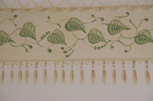 a curtain with green leaves on a wall at Hotel Portici in Vicoforte