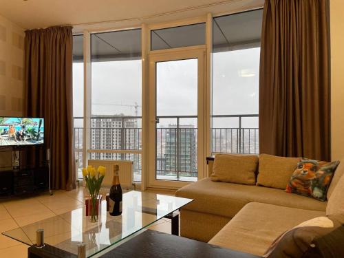 a living room with a couch and a large window at Мост сити АПП 151 с терассой in Dnipro
