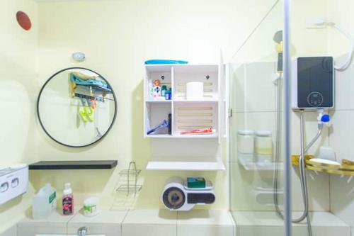 een badkamer met een douche en een spiegel bij Cheapest Staycation at the Metro in Manilla