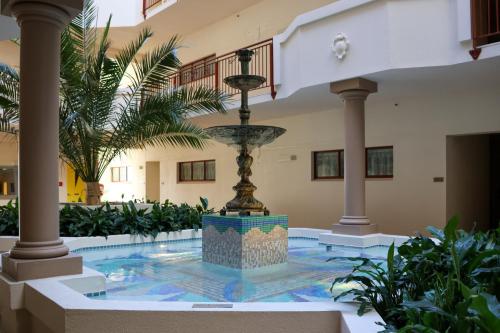 a fountain in the middle of a building with plants at Fino Hotel & Suites in Christchurch