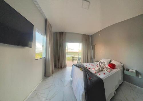 a bedroom with a bed and a window and a television at Villa brisa icaraizinho suíte premium 1 andar in Amontada