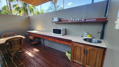 a kitchen with a counter with a microwave and a sink at T's Resort & Motel in Port Macquarie