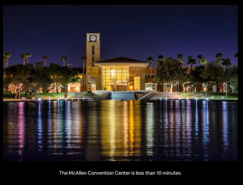 a building with a clock tower next to a body of water at Fully Furnished 3BR and 2BA Gem Near Airport & Mall in McAllen