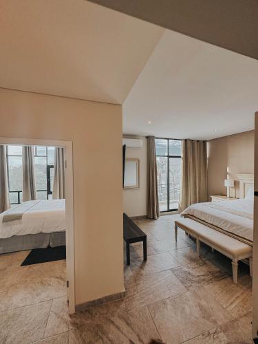 ein großes Schlafzimmer mit zwei Betten und einem großen Fenster in der Unterkunft Suites Lassa in Ensenada