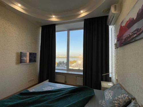 a bedroom with a bed and a large window at Мост сити АПП 52 Джакузи in Dnipro