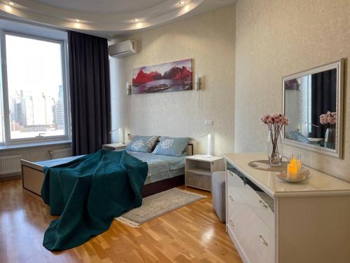 a bedroom with a bed and a desk in it at Мост сити АПП 52 Джакузи in Dnipro