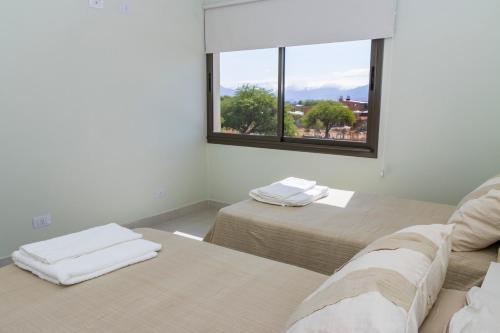 zwei Betten in einem Zimmer mit Fenster in der Unterkunft Refugio Vertientes in Cafayate