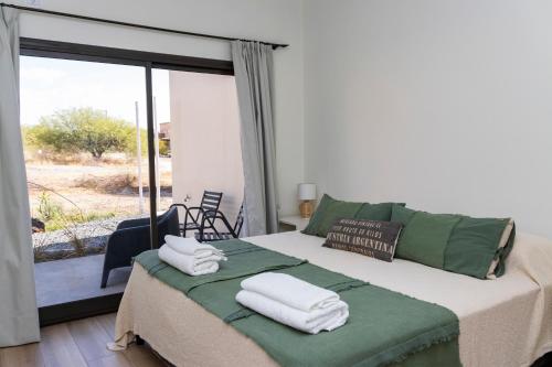 ein Schlafzimmer mit einem Bett mit Handtüchern darauf in der Unterkunft Refugio Vertientes in Cafayate