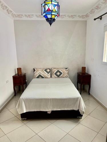 a bedroom with a bed and a stained glass chandelier at appartement traditional cozy in Tangier